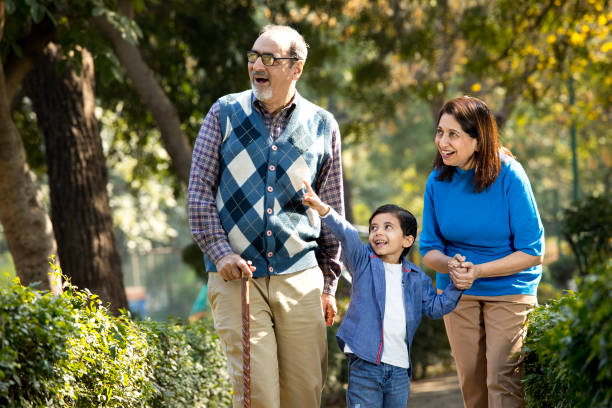 Happy grandparents spending leisure time with little grandson Happy grandparents spending leisure time with little grandson at park indian man walking in park stock pictures, royalty-free photos & images