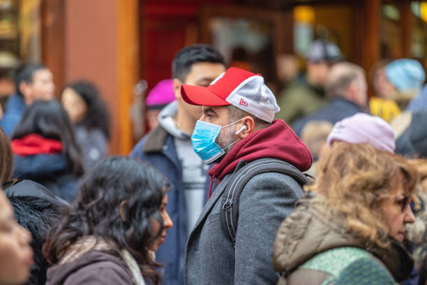 menschen, die eine gesichtsmaske tragen, um sich wegen der epidemie in china zu schützen. selektiver fokus. konzept der coronavirus-quarantäne. - konzepte fotos stock-fotos und bilder