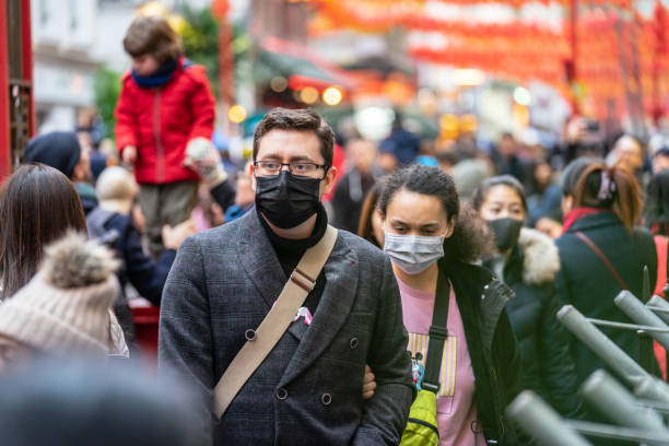 menschen, die eine gesichtsmaske tragen, um sich wegen der epidemie in china zu schützen. selektiver fokus. konzept der coronavirus-quarantäne. - epidemie stock-fotos und bilder