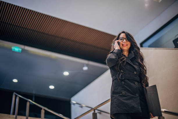 istock Smiling woman is talking on phone 1202557070