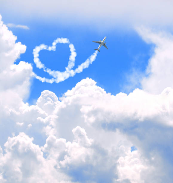 Girl shows her hands in a form of heart on the airplane in open hatch of a vehicle. Travel concept