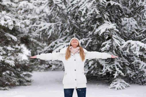 Young woman enjoying snow, playing with snowball, winter time, fun, holidays