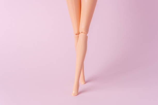 istock Doll legs on pink background. Creative minimal summer concept. 1202559991