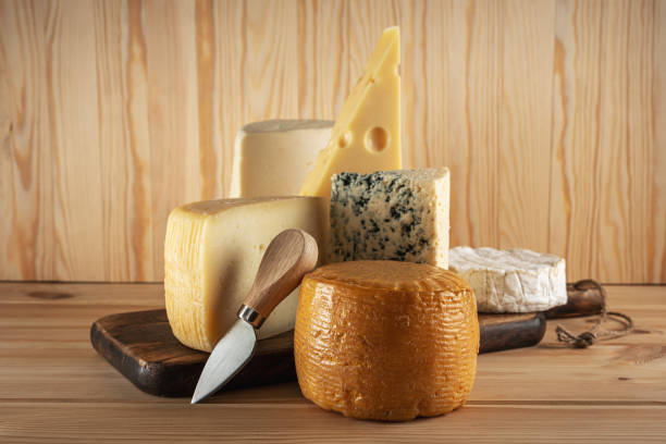 istock Assortment of different cheese types on wooden table. Cheese background. 1202560052