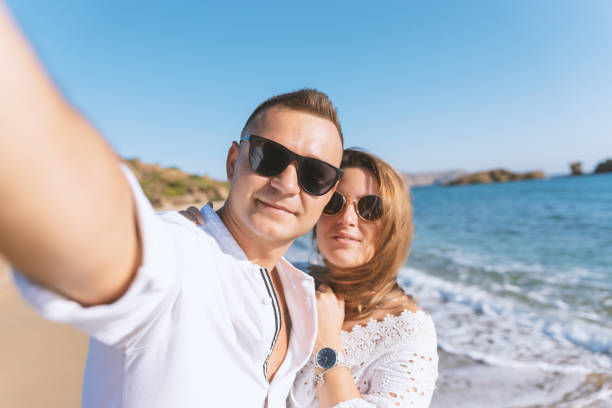 istock Young happy couple taking selfie on the beach. Summer vacations concept. 1202560132