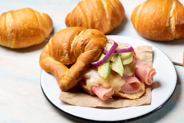 istock Butter croissant bread with ham and cheese on wooden background 1202560241