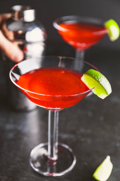 istock Red cocktail with lime in Martini glass on a table. 1202561344