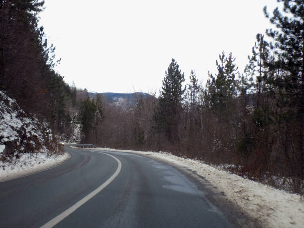 istock Driving the winding road through the woods during the winter 1202561469