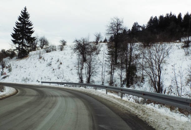 istock Driving the winding road through the woods during the winter 1202561486