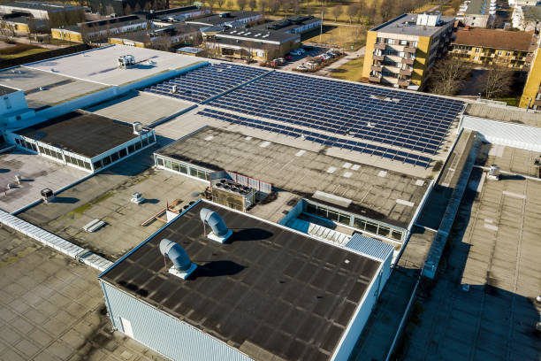 aerial view of many photo voltaic solar panels mounted of industrial building roof. - voltaic imagens e fotografias de stock