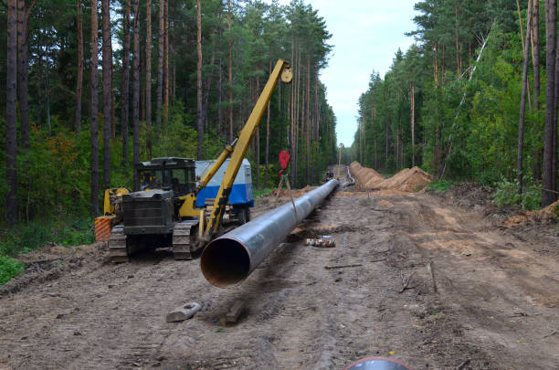 Crawler crane with side boom or pipelayer bulldozer. Natural gas pipeline construction work.