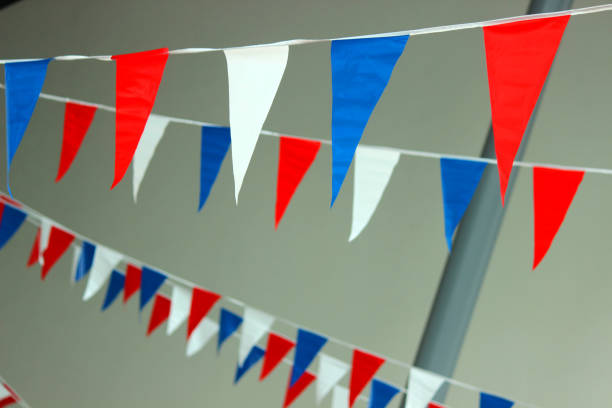 istock Image of red, white and blue bunting flags in rows against outdoor background 1202565548