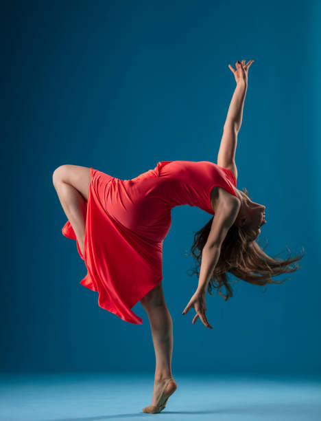 istock Dancer in red dress on blue background 1202565672