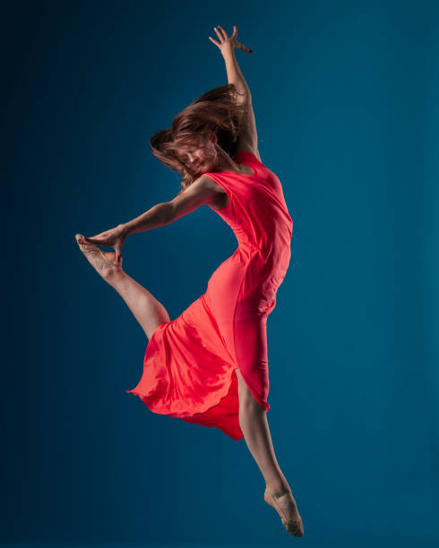 istock Dancer in red dress on blue background 1202565673