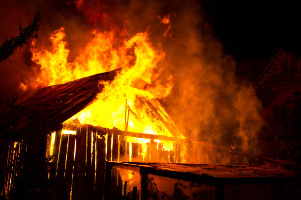 istock Wooden house or barn burning on fire at night. 1202566908