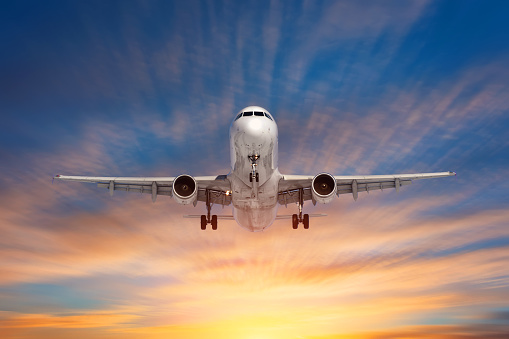 Evening flight of a passenger airplane on a background of beautiful sky