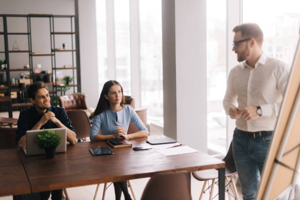 istock Young casual businessman presenting new project to partners 1202570343