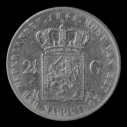 Macro close-up van een zilveren Nederlandse rijksdaalder (twee gulden en vijftig cent), de munt is in 1845 gemaakt en laat het wapenschild van Nederland zien. Achtergrond is zwart