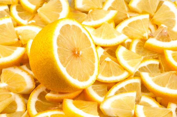 istock One cut lemon lies on a background of lemon slices. 1202576113