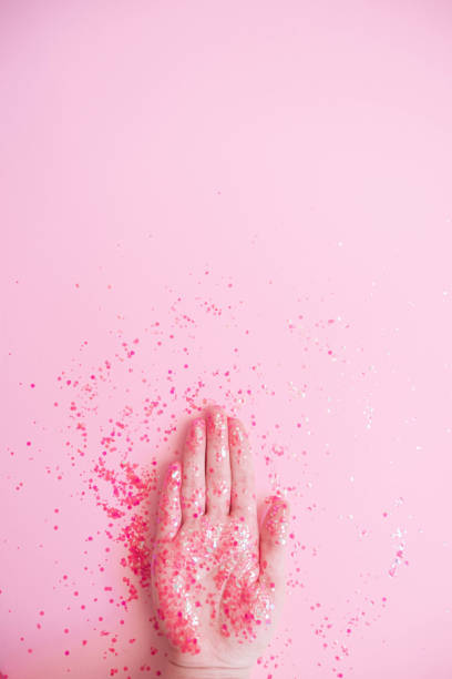 istock Hand in glitter on pink pastel background 1202576193
