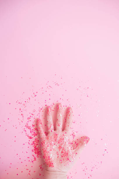 istock Hand in glitter on pink pastel background 1202576200