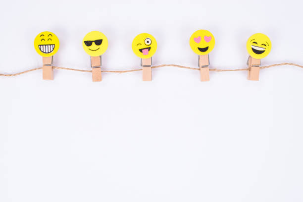Top above high angle close up view photo of five nice glad smiley faces hanging on string isolated white wall
