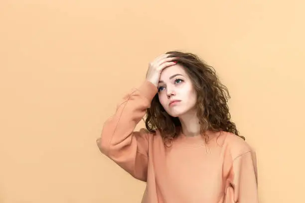 Photo of Portrait of a young beautiful woman wearing sweatshirt posing isolated over yellow background