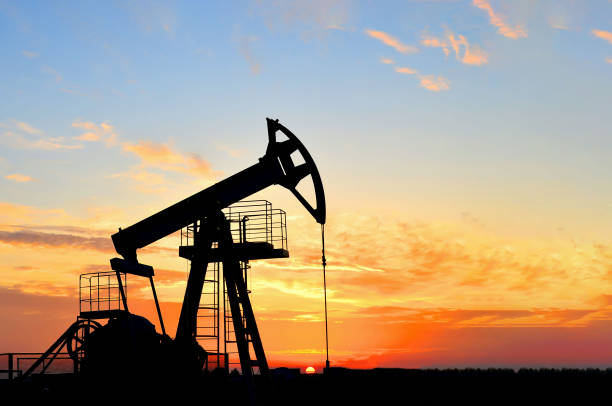 istock Pumpjack (Oil Rig) In The Sunset. Oil drill rig and pump jack 1202577681
