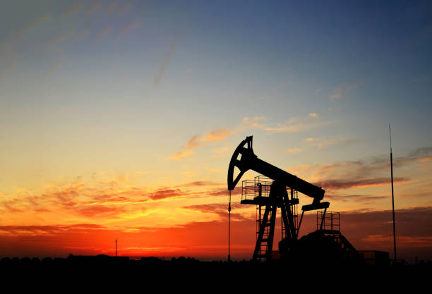 istock Pumpjack (Oil Rig) In The Sunset. Oil drill rig and pump jack 1202577682