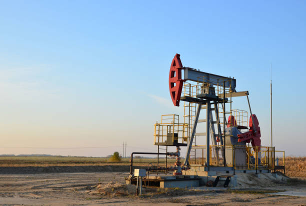 istock Pumpjack (Oil Rig) In The Sunset. Oil drill rig and pump jack 1202577697