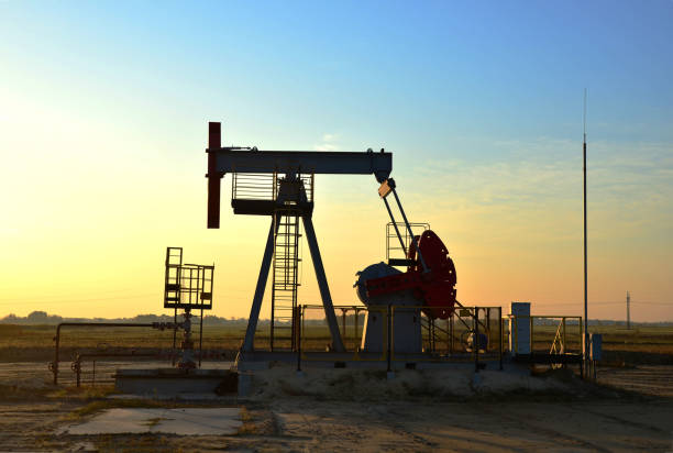istock Pumpjack (Oil Rig) In The Sunset. Oil drill rig and pump jack 1202577720