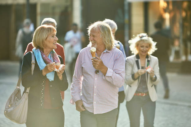 istock Smiling Senior Friends Walking and Enjoying Ice Cream 1202580314