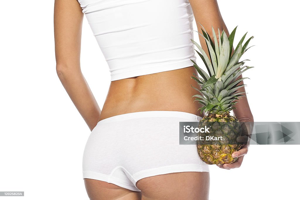 tightened woman's buttocks in white linen with pineapple tightened woman's buttocks in white linen with pineapple  isolated white.  Cellulite concept Adult Stock Photo