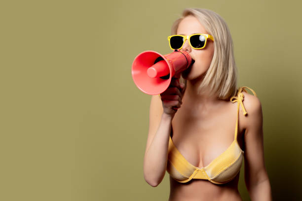 istock Beautiful blonde woman in bikini with loudspeaker 1202583543