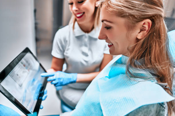 Female dentist with digital tablet. Modern treatment in professional dental clinic. Female dentist with digital tablet. Modern treatment in professional dental clinic. Side view tablet pc and digital hospital tools stock pictures, royalty-free photos & images