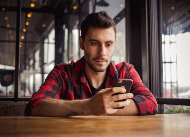 istock happy young man using social media at cafe 1202586381
