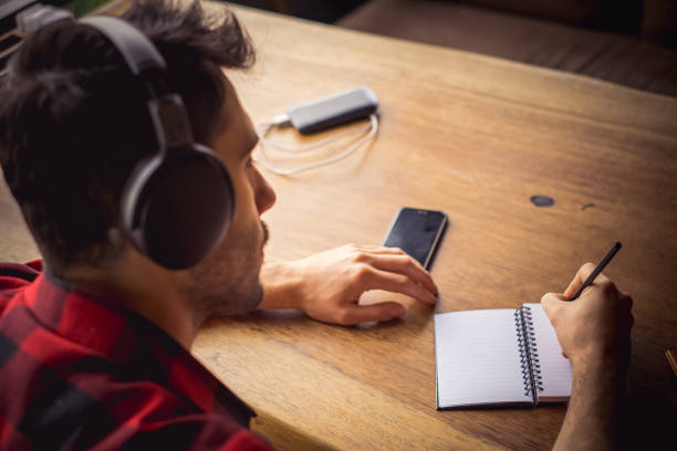 young man listening and working at cafe