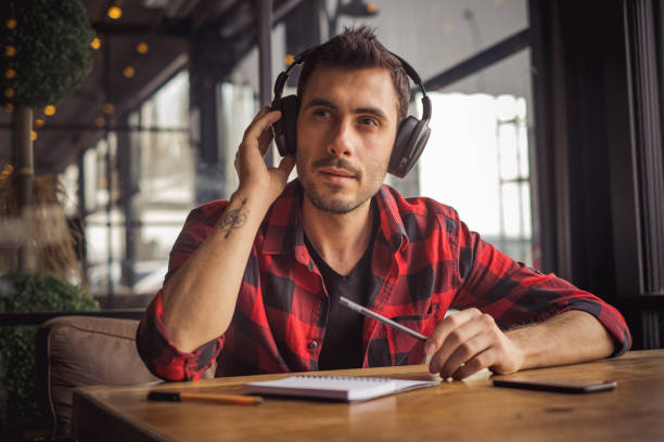 istock young man listening and working at cafe 1202588042