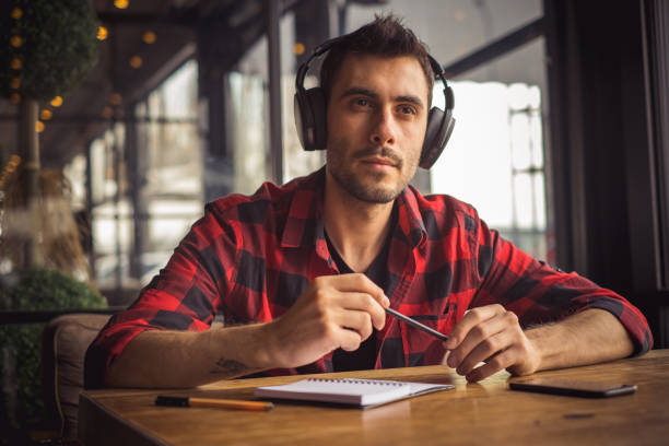 istock young man listening and working at cafe 1202589395