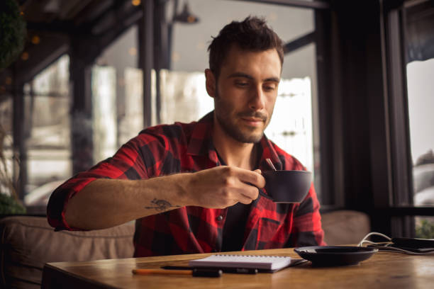 istock young man drinking a cup of coffee at cafe 1202589835