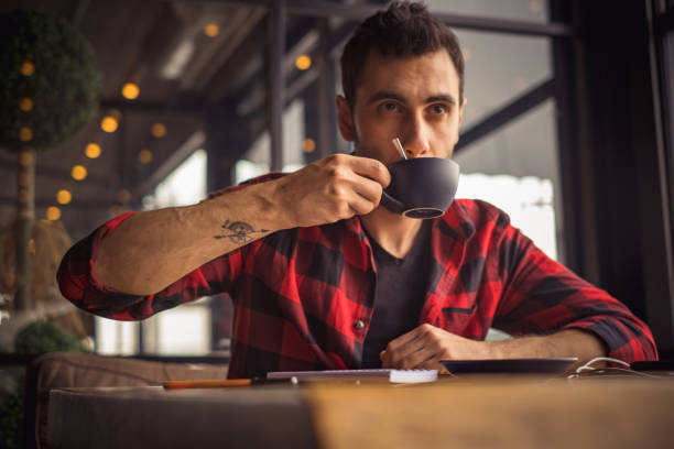 istock young man drinking a cup of coffee at cafe 1202590145