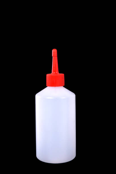 istock white plastic bottle with red spout isolated on black background 1202591152