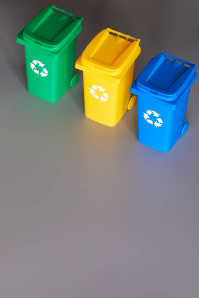 istock Three color coded recycle bins, isometric projection on grey paper background with copy-space. Recycling sign on the bins, blue, yellow and green. Waste separation, reduce mixed waste in landfill 1202593275