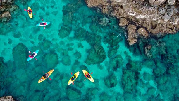 blick auf eine drohne von einer drohne menschen sind kajak im meer - kayaking kayak sea coastline stock-fotos und bilder