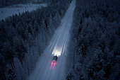 Aerial view of a snow road going through in the snow covered forest in Finland