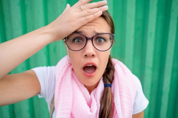 Young caucasian woman making ok gesture like binoculars with her hands and grimacing, eyes stare through fingers