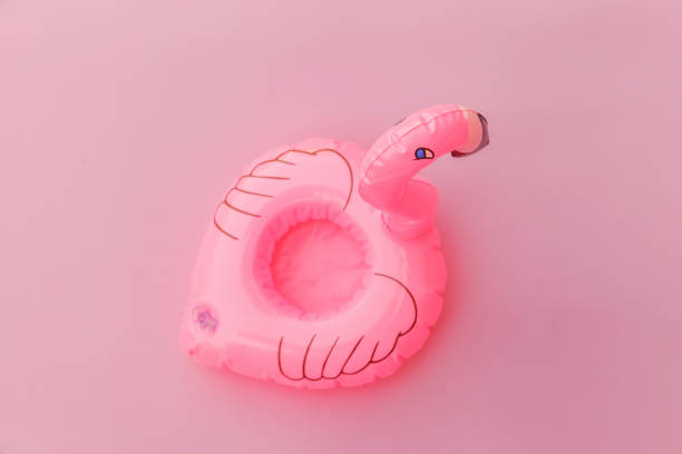 istock Summer beach composition. Simply minimal design with Inflatable flamingo isolated on pastel pink background. Pool float party, trendy celebrity fashion concept. Flat lay top view copy space 1202605348