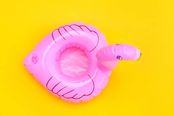 istock Summer beach composition. Simply minimal design with pink Inflatable flamingo isolated on yellow background. Pool float party, trendy celebrity fashion concept. Flat lay top view copy space 1202605399