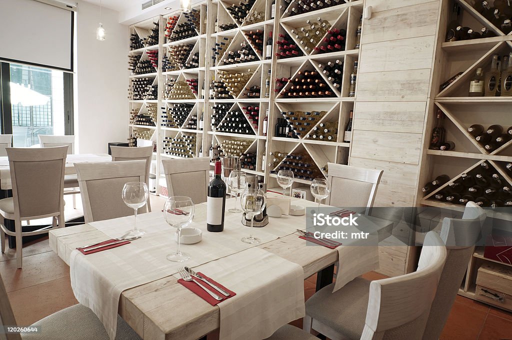 Table with glasses in wine bar Wine glasses and bottles on the table in wine bar and shop Liquor Store Stock Photo