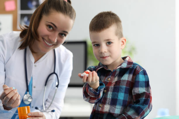 istock Happy kid with doc in clinic 1202612425